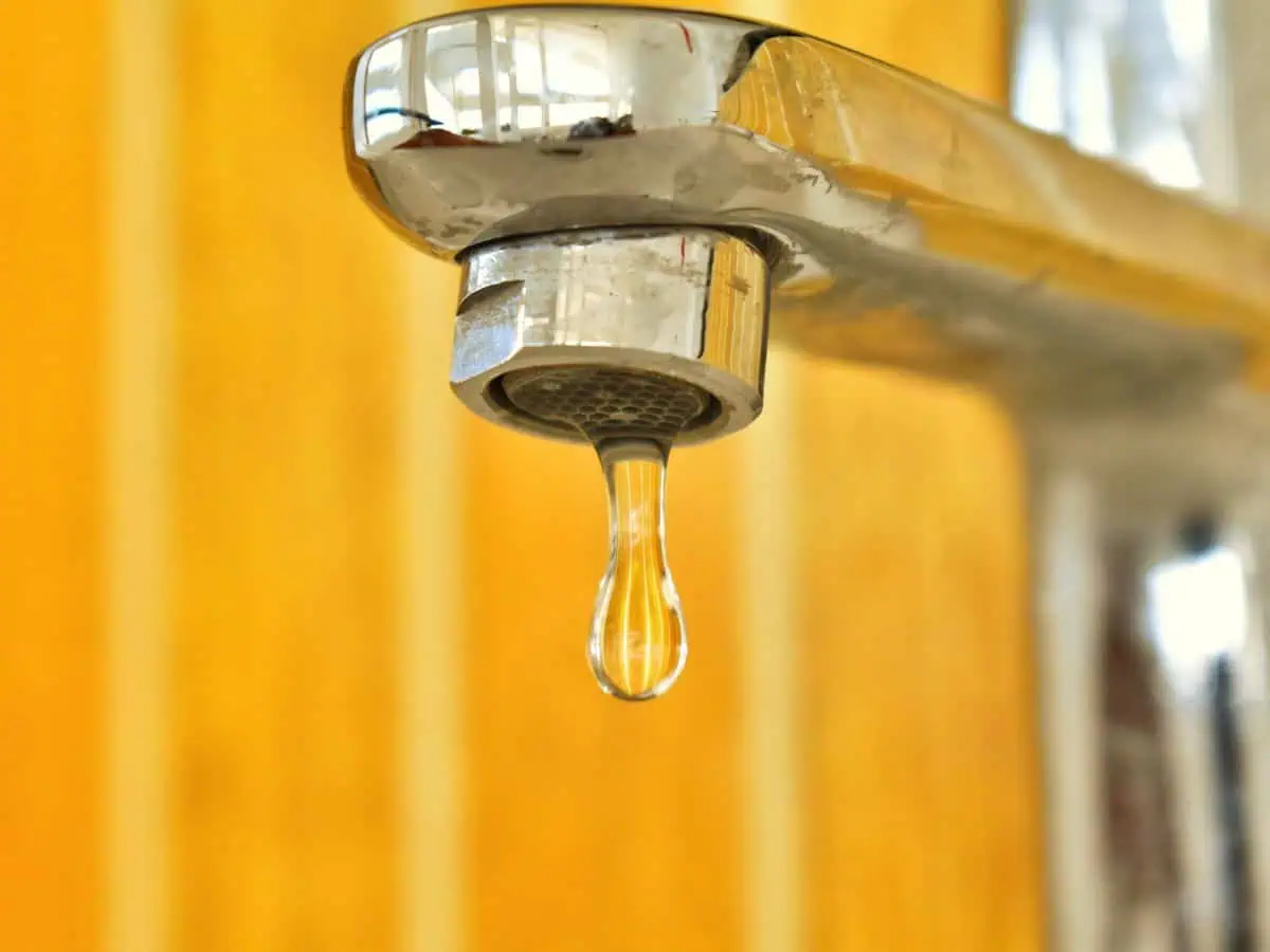 Lower Your Water Bill This Summer With These Tips 1 a water droplet coming out of a faucet