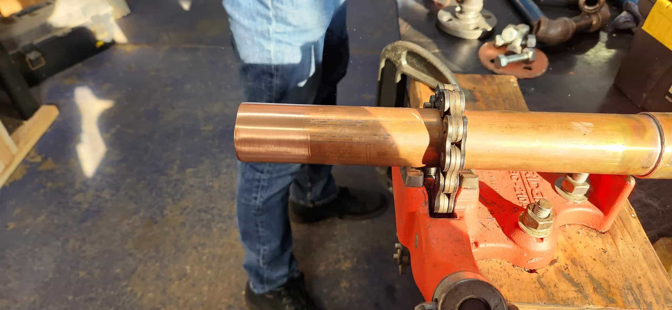 A skilled worker is using a wrench to repair a pipe in a professional setting