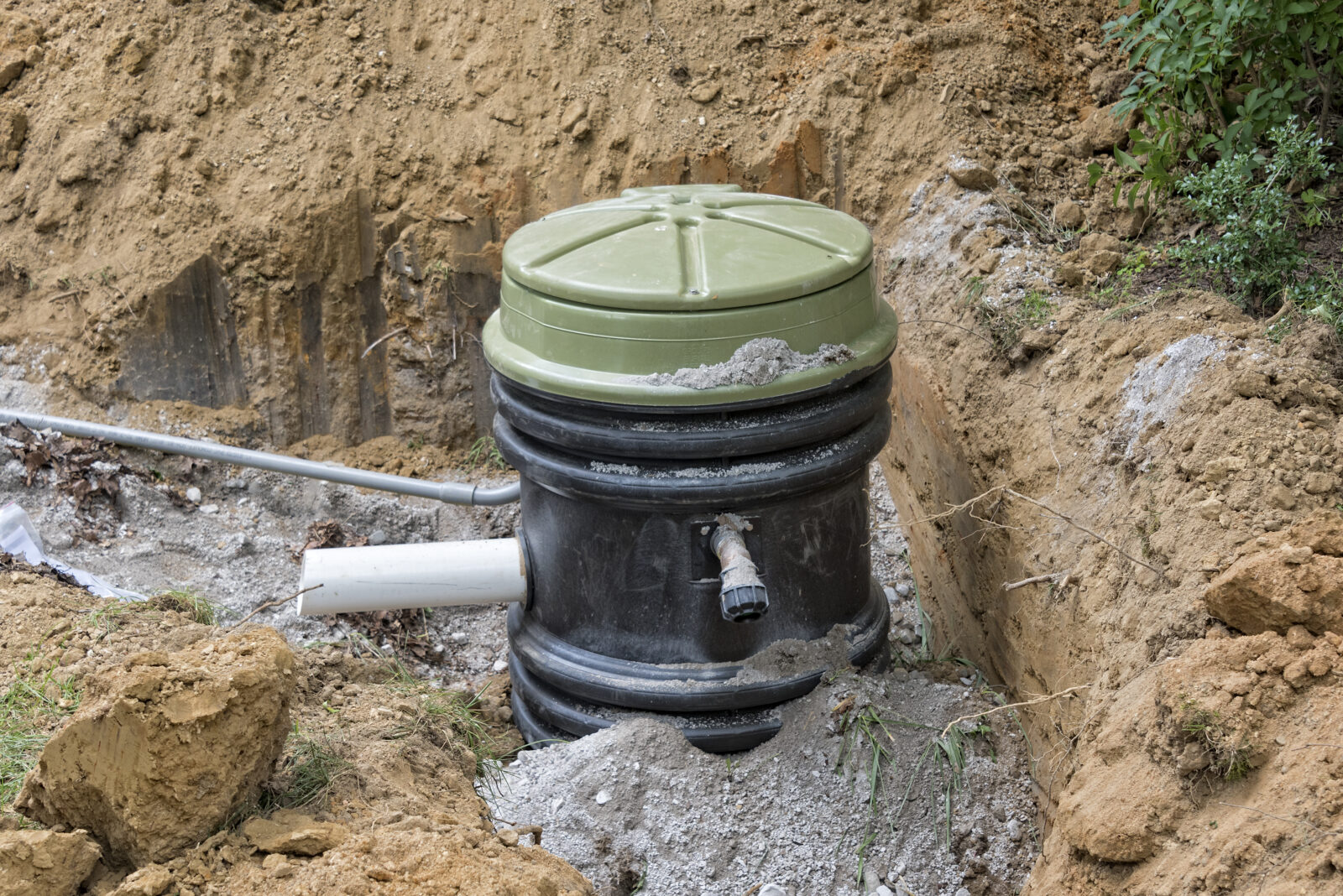 Sewer Pumps: Sewer grinder pump being installed outside of a building