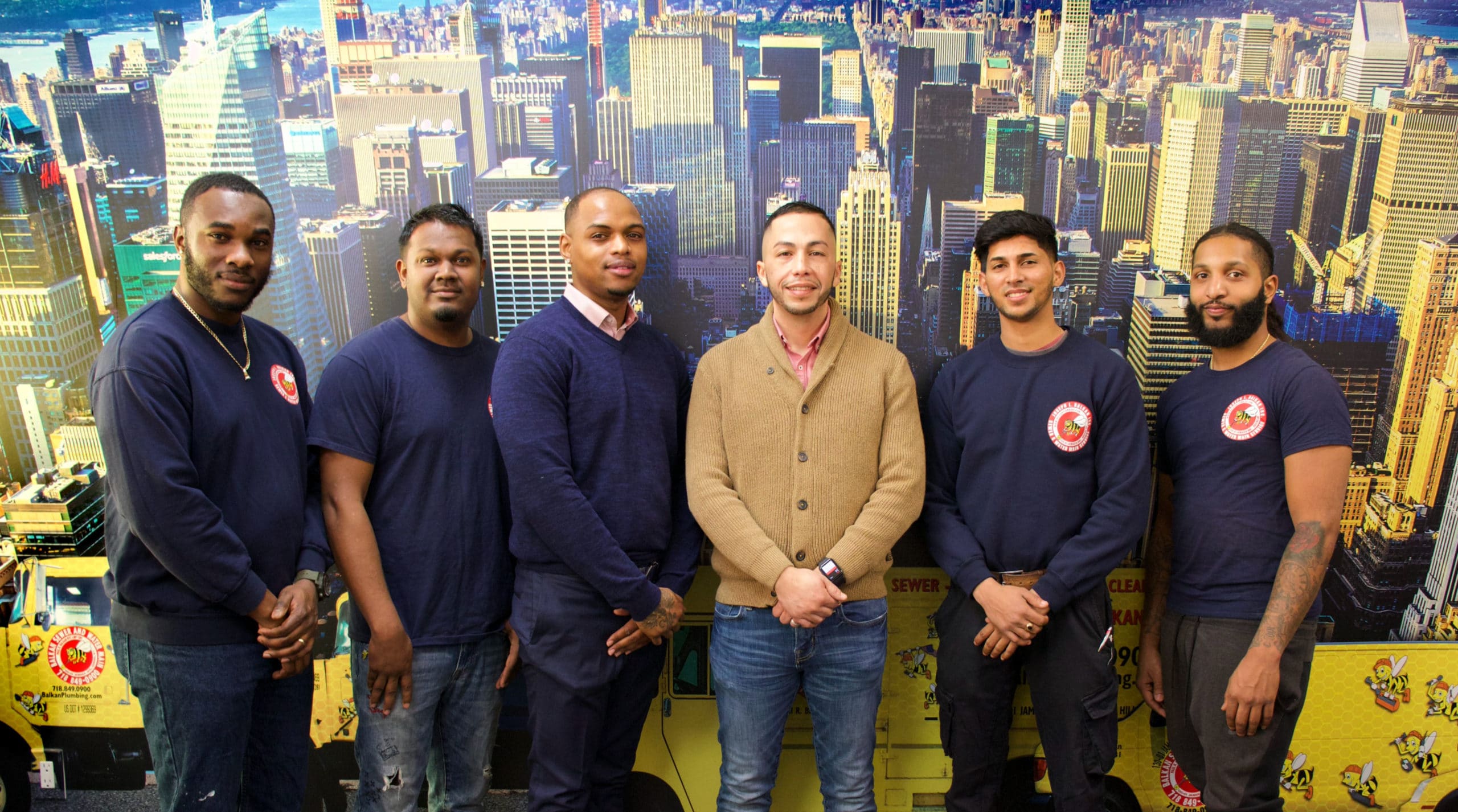 6 smiling people posing, dressed in uniform