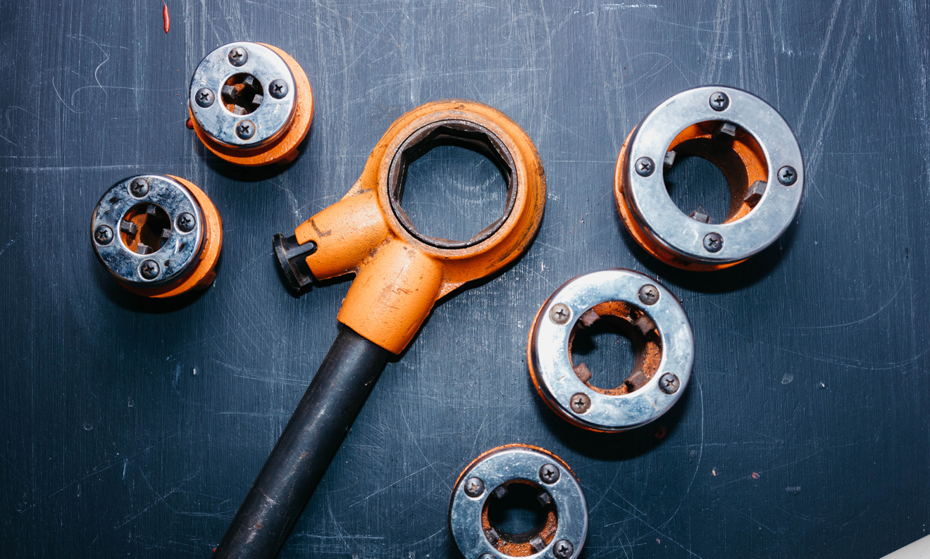 The Ultimate Pipe Threading Guide With Videos: Learn How to Thread Pipe for Plumbing or Gas 4 pipe die heads on a table.