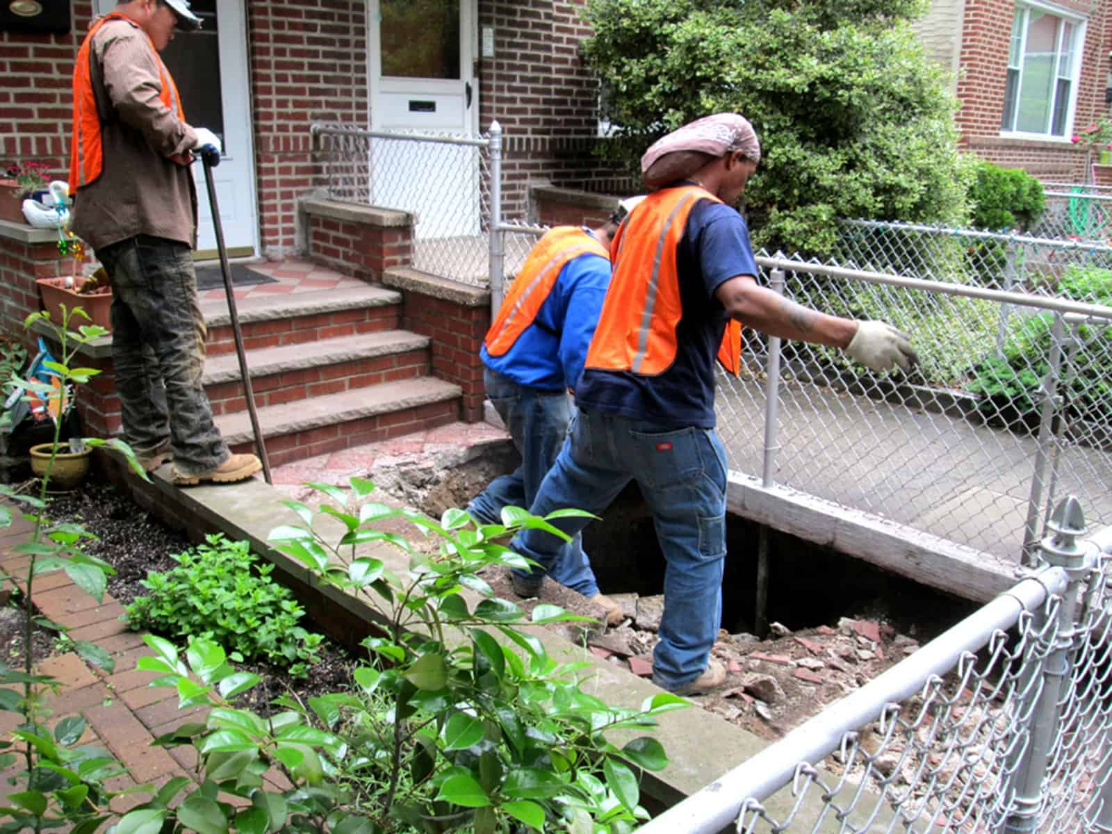 Sinkhole inside a property with workers digging a hole