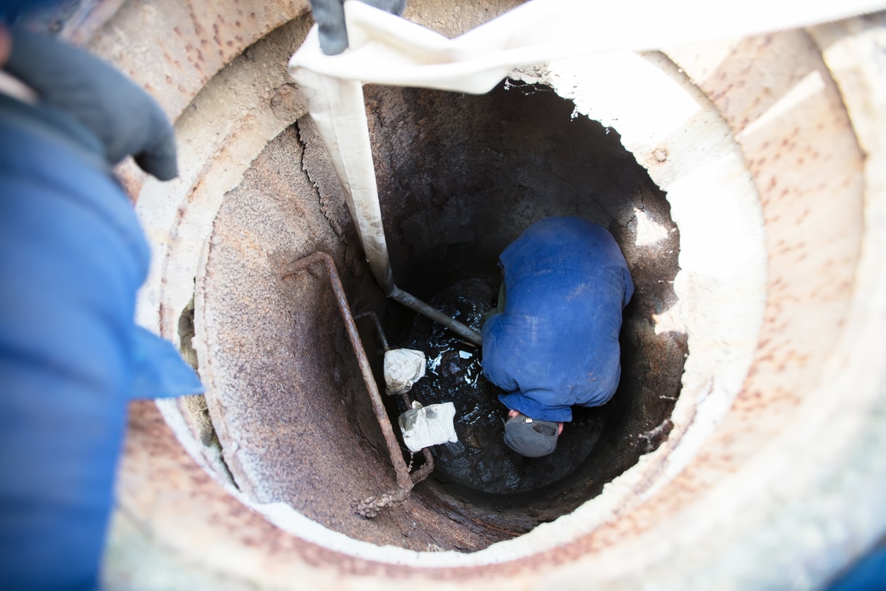 Professional plumbers checking a commercial sewer system - checking for sewer problems.